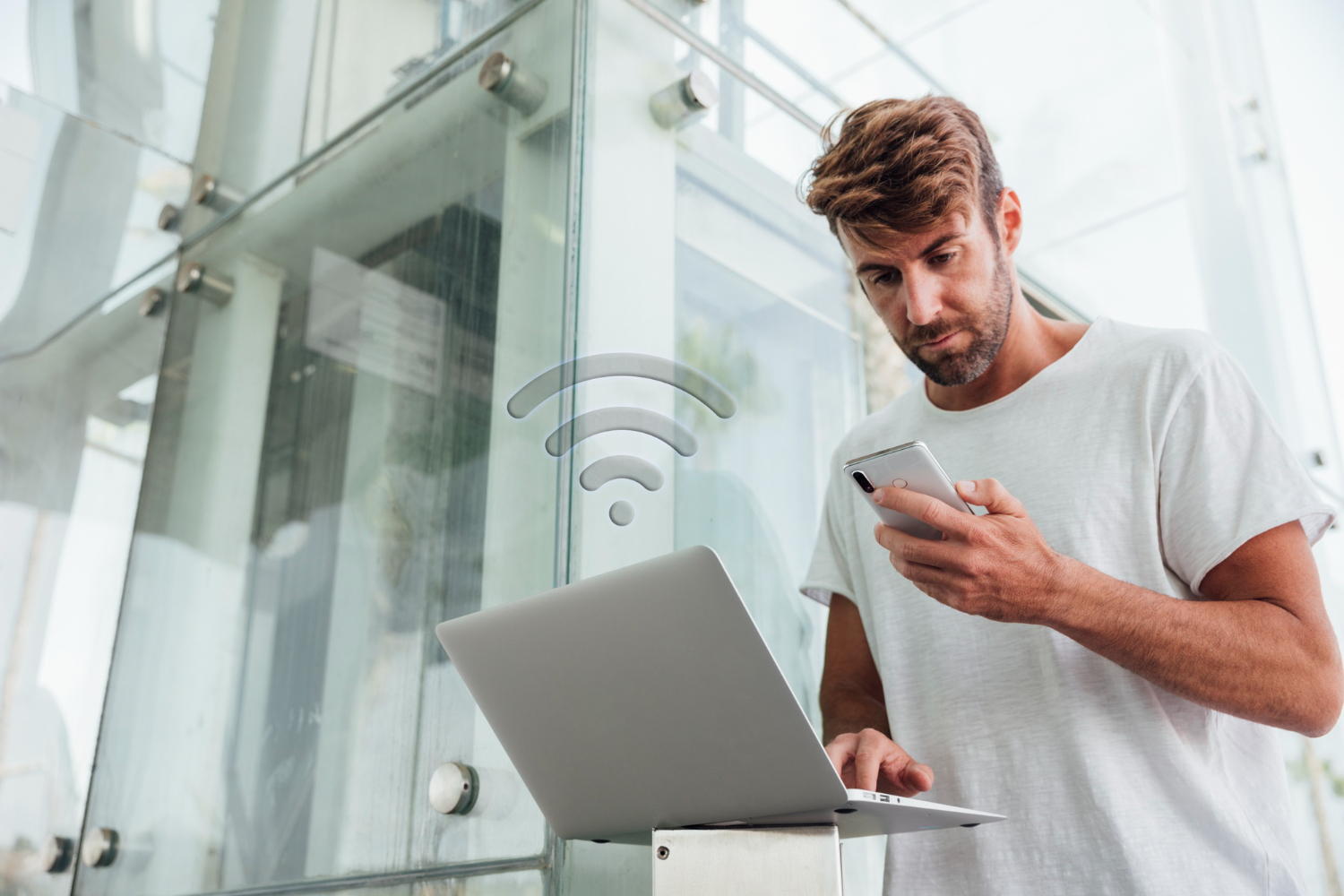 Voyageur connecté au WiFi d'une location saisonnière avec son ordinateur et son téléphone